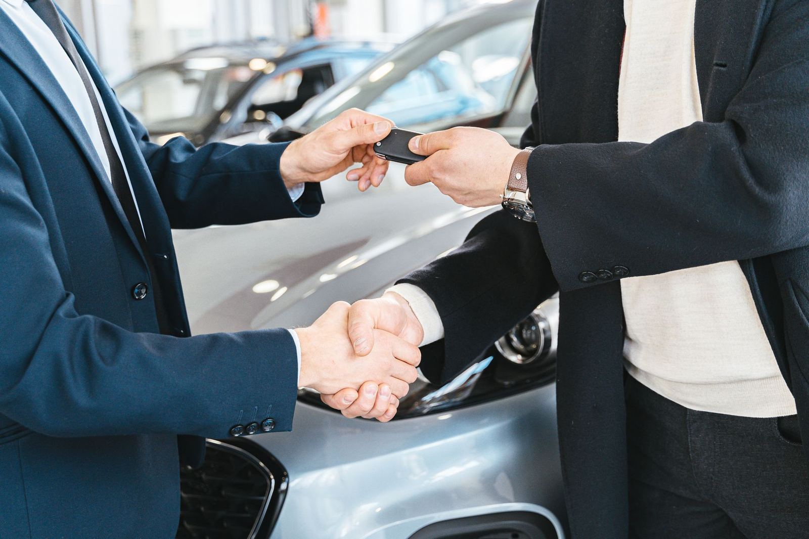 Hand receiving car keys at a rental desk
