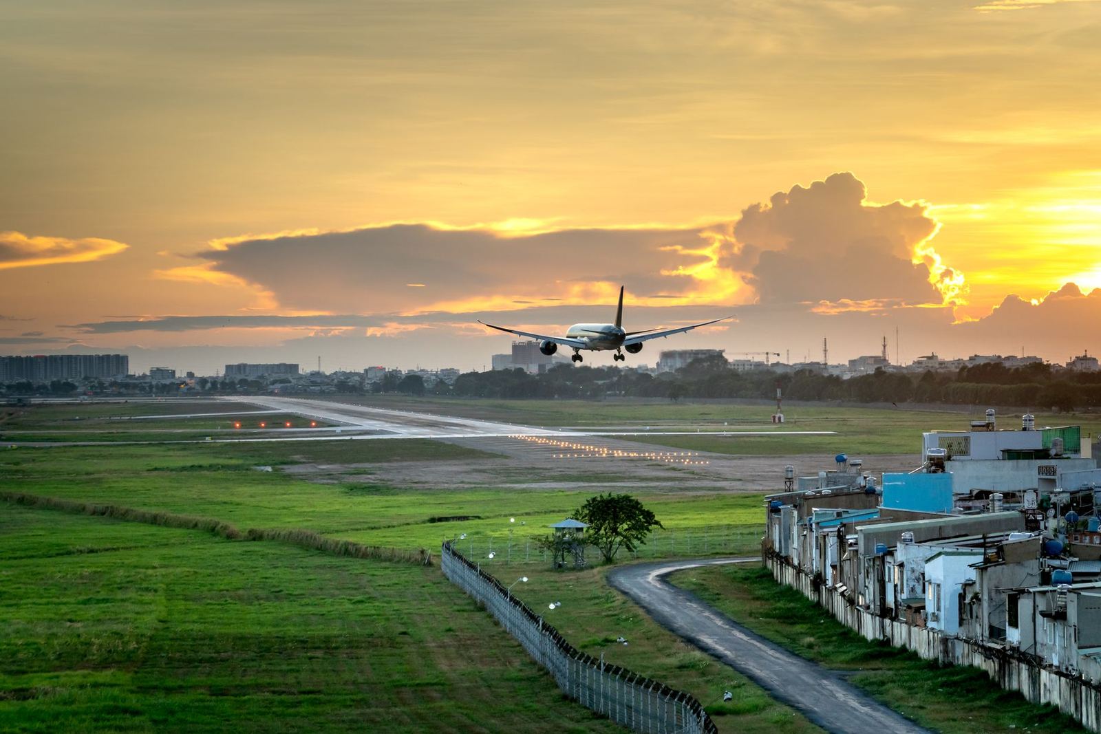Airliner climbing away from a runway at sunset